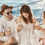 tres amigos riendose mientras beben en un barco