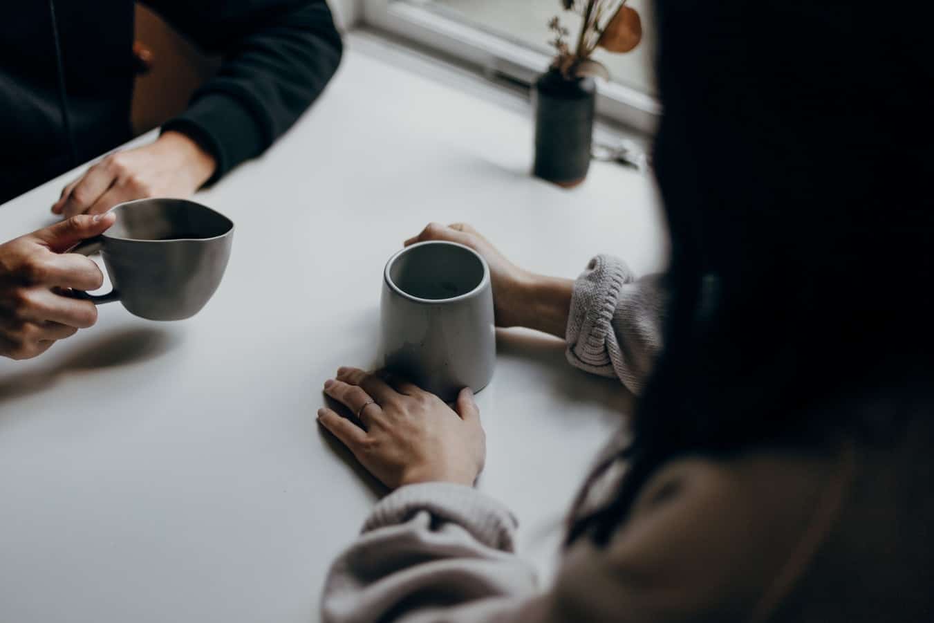 personas conversando mientras toman una taza de cafe