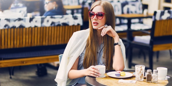 mujer guapa sentada en una cafeteria mientras toma un cafe