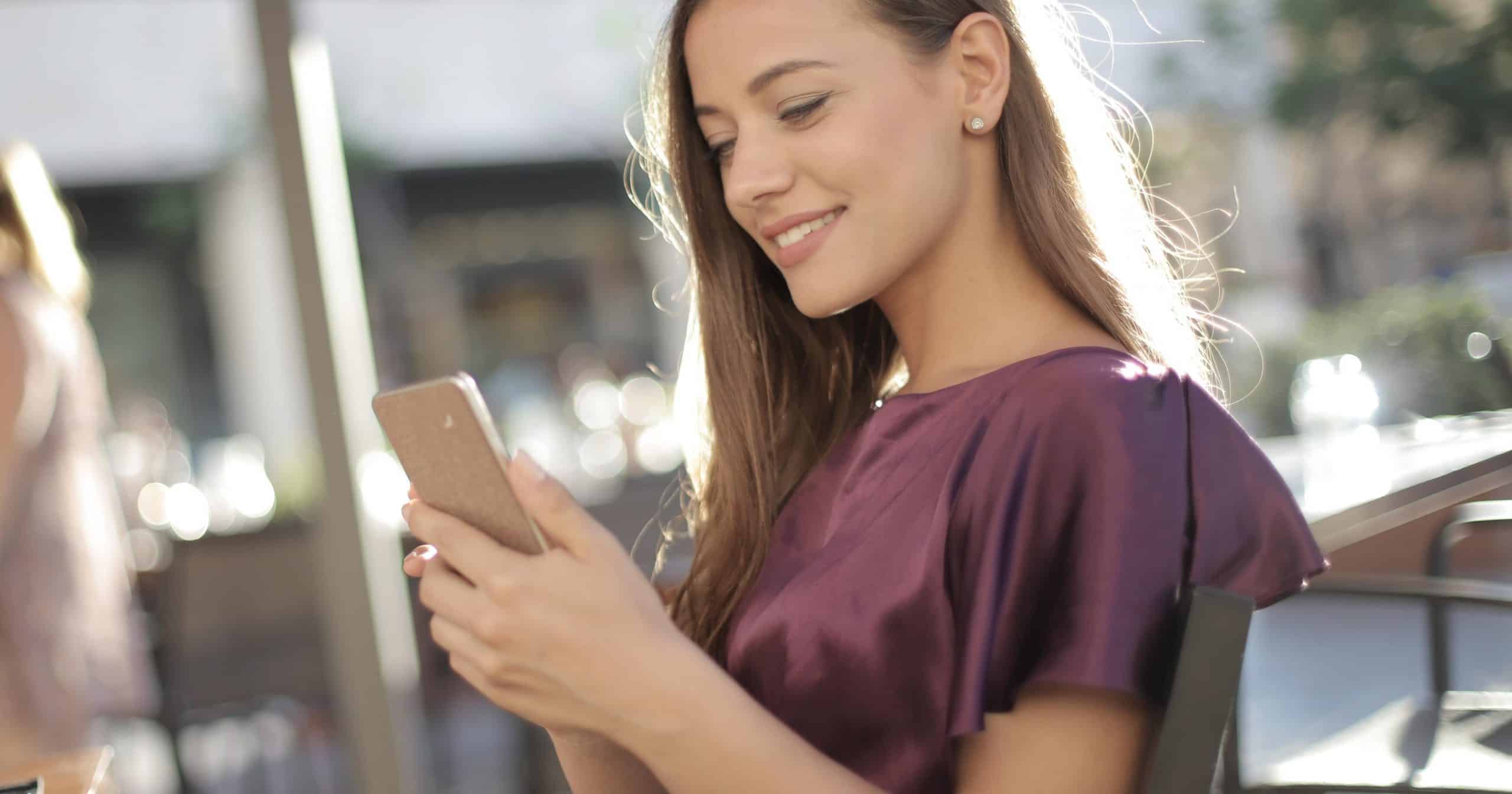 mujer sonriente sujetando un movil