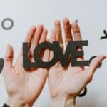 manos con unas letras que pone amor en ingles (love)